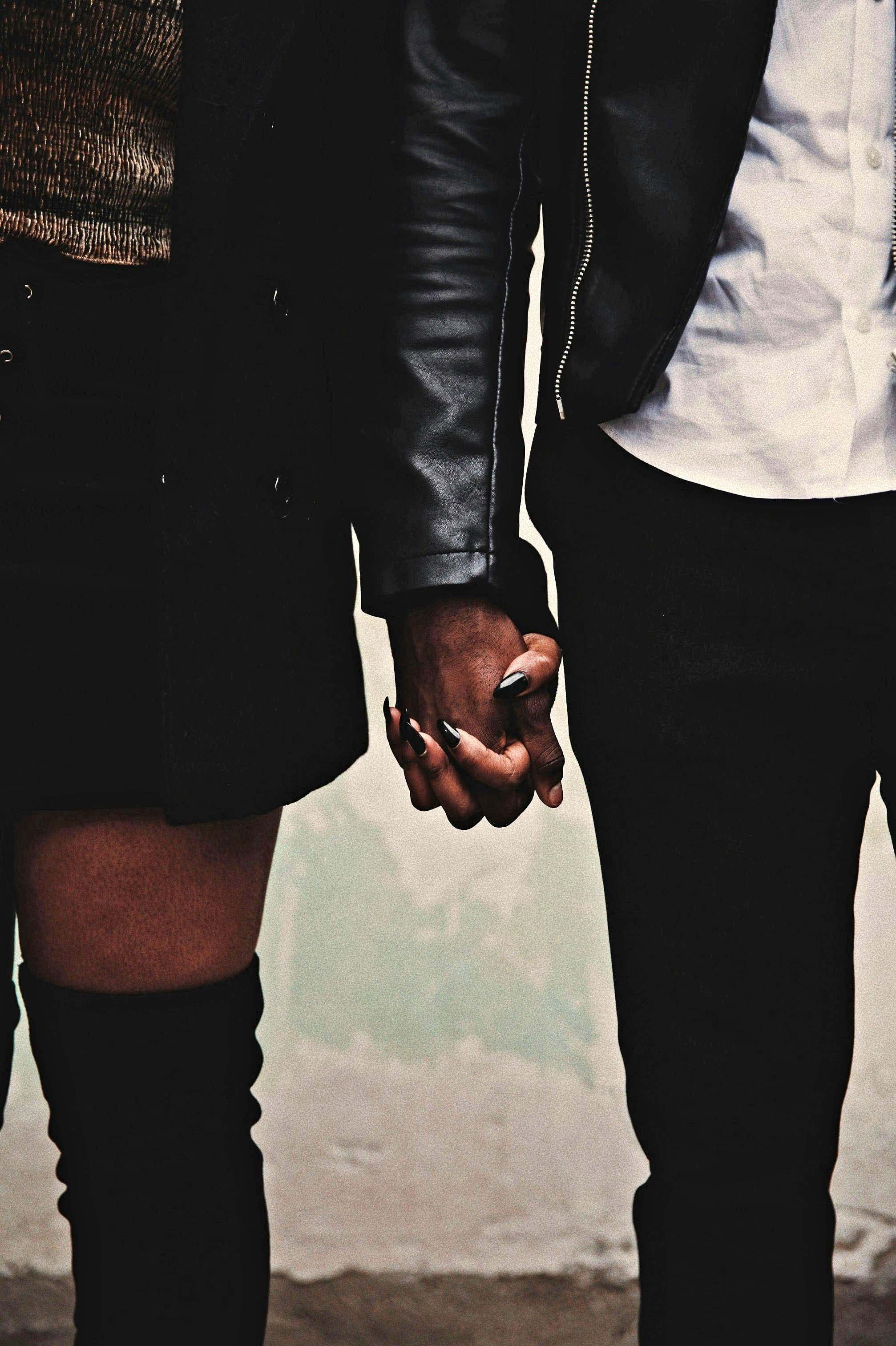 A couple hold hands after healing their anxious attachment with the help of a date coach